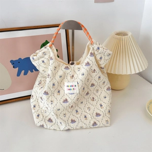 Detail of quilted beige canvas bag with rabbit patterns and woven rope handles