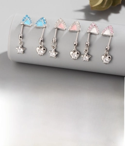 Detailed view of titanium cat ear piercing studs with pink zircon and star pendant