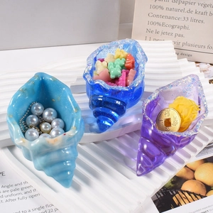 Dettaglio di contenitori in resina a forma di conchiglia in blu e viola con glitter