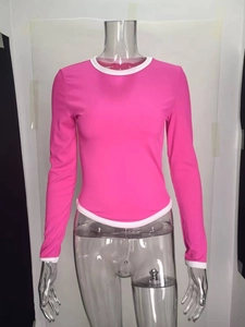 Détail du tricot côtelé et liseré blanc contrasté sur le haut rose à manches longues