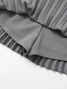 Detail of grey high waist pleated skirt showing inner lining and fine woven texture