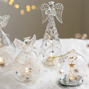 Luminous glass Christmas angel ornaments with warm bokeh lights for festive table decor