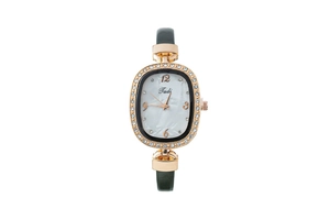 Gros plan du boîtier de montre doré ovale avec cristaux et bracelet en cuir vert