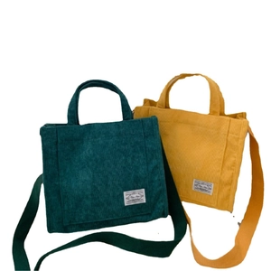 Corduroy tote bags in green and yellow with adjustable straps and top handles