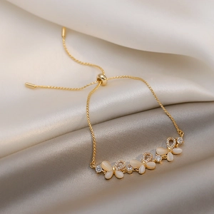 Close-up of a gold butterfly bracelet with opal stones and sparkling zircon accents
