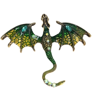 Vintage green enamel flying dragon brooch with crystals and gold finish on white background