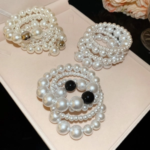 Detail of elegant multilayer pearl bracelets with silver accents in a pink jewelry box