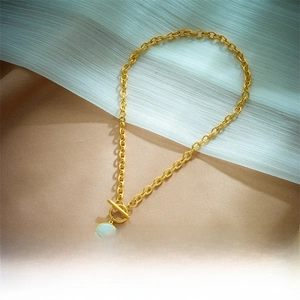 Detail of gold chain necklace with round pendant and classic T-bar OT toggle clasp