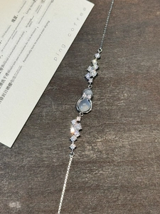 Macro detail of silver bracelet featuring gourd pendant with blue chalcedony and zircons