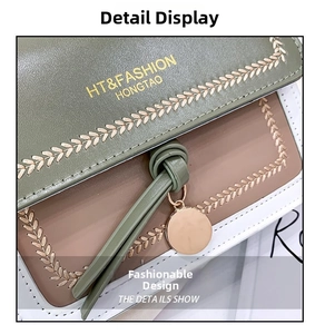 Detail of tricolor leather handbag showing wheat embroidery and gold metal logo
