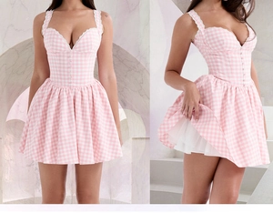 Detail of pink plaid mini dress featuring lace straps and ruffled hemline texture