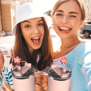 Pink cherry blossom straw covers on tumblers shown in a cheerful lifestyle selfie scene