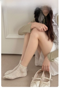 Detail of beige agaric lace socks with mesh texture and elegant wavy edge design