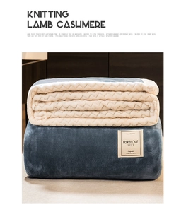 Detail of navy blue knitted blanket with thick cream faux lamb wool lining and plush texture