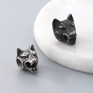Detailed macro view of two wolf head stainless steel charms for DIY jewelry making