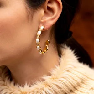 Vintage 18K gold-plated C-shaped earrings with pearls and crystals on a model