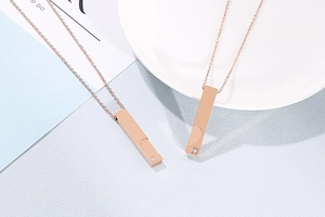 Détail de pendentifs rectangulaires en or rose avec strass sur une assiette blanche