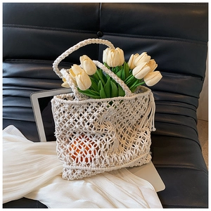 Detail view of cream macrame woven tote bag with intricate hollow knit pattern