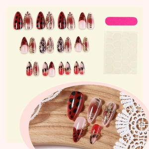 French leopard print press-on nails with red cherry accents and gold cross charms