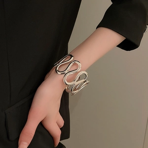 Macro view of silver wave cuff bracelet with hollowed design on model wrist