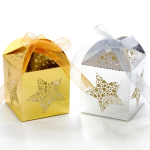 Detail view of gold and silver star laser-cut gift boxes with ribbon bow closure