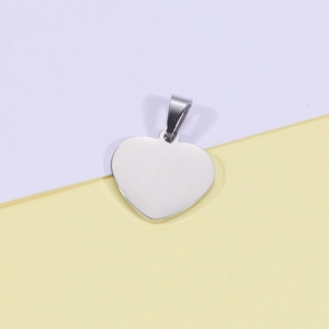 Macro detail of polished stainless steel heart pendant with clasp on two-tone background