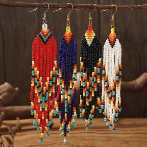 Bohemian handmade beaded tassel earrings in four colors on a natural wood branch