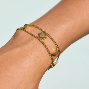 Double-layered gold star and moon stainless steel bracelet worn on a woman's wrist