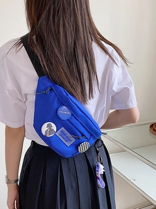 Blue nylon crossbody bag for women with badges and a cute cartoon plush keychain