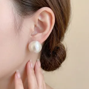 Minimalist geometric half-sphere gold plated stud earrings worn on female ear