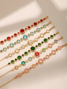 Detail of elegant gold bracelets featuring colorful round multi-faceted zircon stones