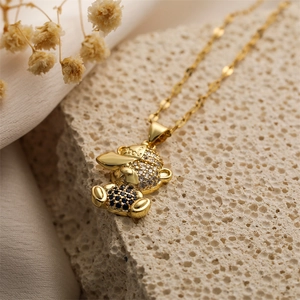 Détail d'un pendentif ours en peluche plaqué or avec zircone cubique et chaîne corde