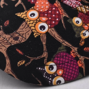 Detailed macro shot of cotton baseball cap brim with colorful owl print and triple stitching