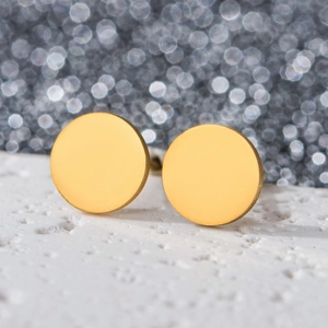 Detailed macro view of minimalist 18K gold-plated round stud earring on stone surface