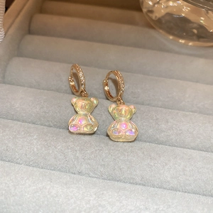 Gros plan sur des boucles d'oreilles dorées avec oxydes de zirconium et oursons aurore