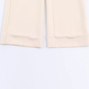 Close-up of beige trousers with professional rolled cuff detail and smooth fabric texture