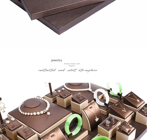 Macro detail of brushed leather jewelry display set with necklace bust and gold trim