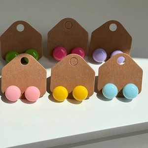 Boucles d'oreilles colorées en forme de haricot dans divers tons vifs sur présentoir