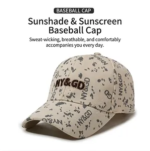 Détail de casquette beige avec motif taches d'encre grise et broderie NY&GD