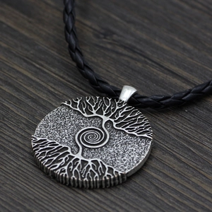 Macro detail of Nordic Viking Yggdrasil tree of life pendant on a black leather cord