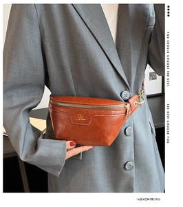Close-up of brown PU leather crossbody chest bag with metal zipper and DM logo on a model