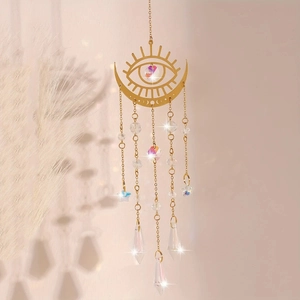 Golden moon and sun catcher with rainbow crystals and metal prism reflecting soft light