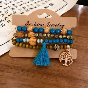 Detail of bohemian multilayer sandalwood beads with turquoise accents and tree of life charm