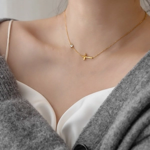 Titanium steel gold cross necklace with side zircon stone on female model's neck