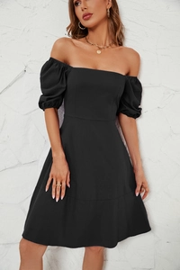 Detail of elegant black off-shoulder dress with puff sleeves and textured fabric