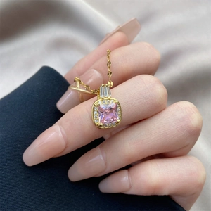 Détail d'un collier avec pendentif pierre rose carrée et diamants sur chaîne dorée