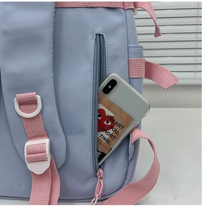 Close-up of light blue backpack side zipper pocket showing functional phone storage space