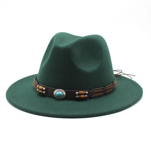 Detail of dark green wide-brim fedora featuring turquoise accents and a brown leather band