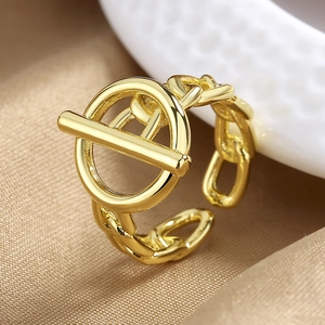 Anillo de cadena dorado con cierre de palanca OT minimalista en un elegante fondo champán