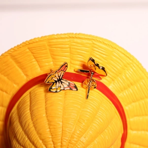 Detailed close-up of butterfly earrings with colorful enamel on a woven background